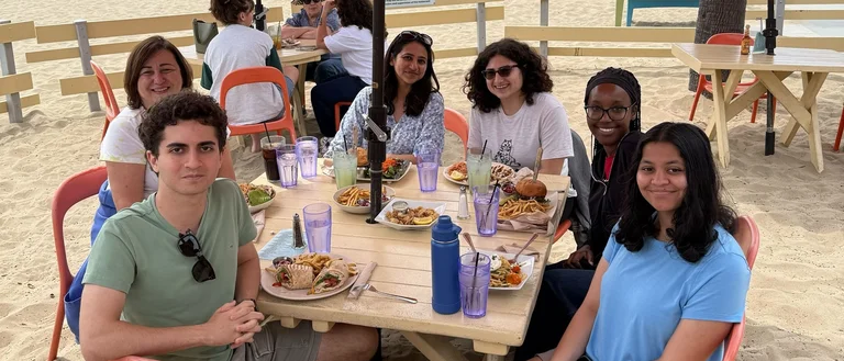 Erbay Lab around a table, getting lunch on the beach